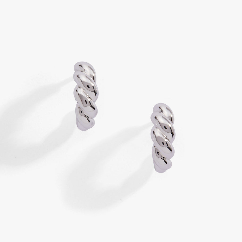 Close up of silver-plated puffy rope textured huggie hoop earrings