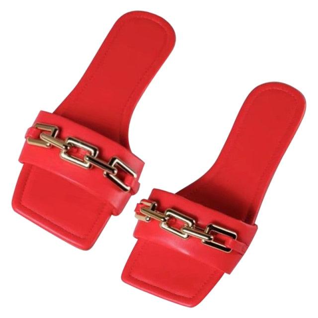 Purple women's flat slides featuring a gold chain detail and square-head design.