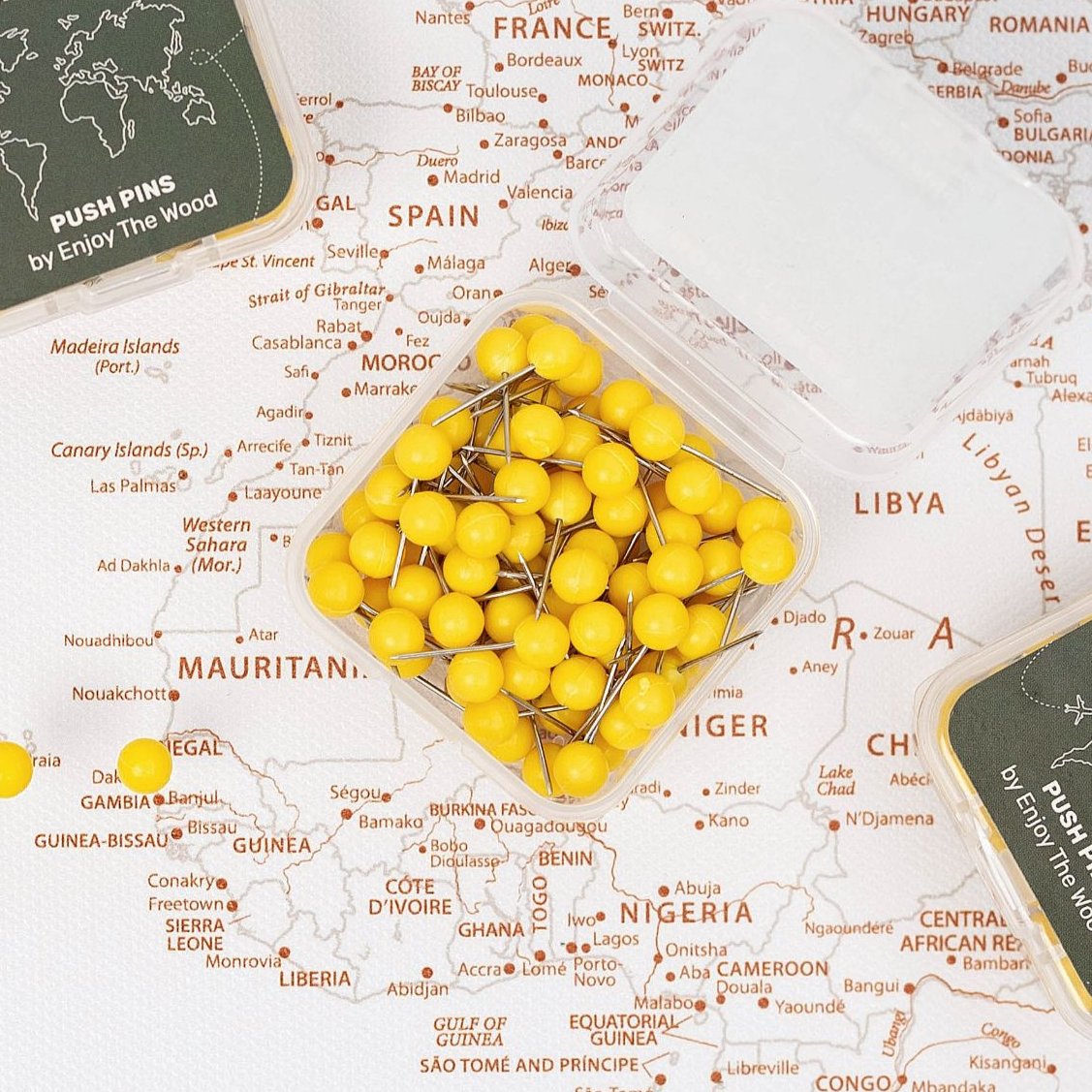 Bright yellow push pins arranged on a canvas wall map