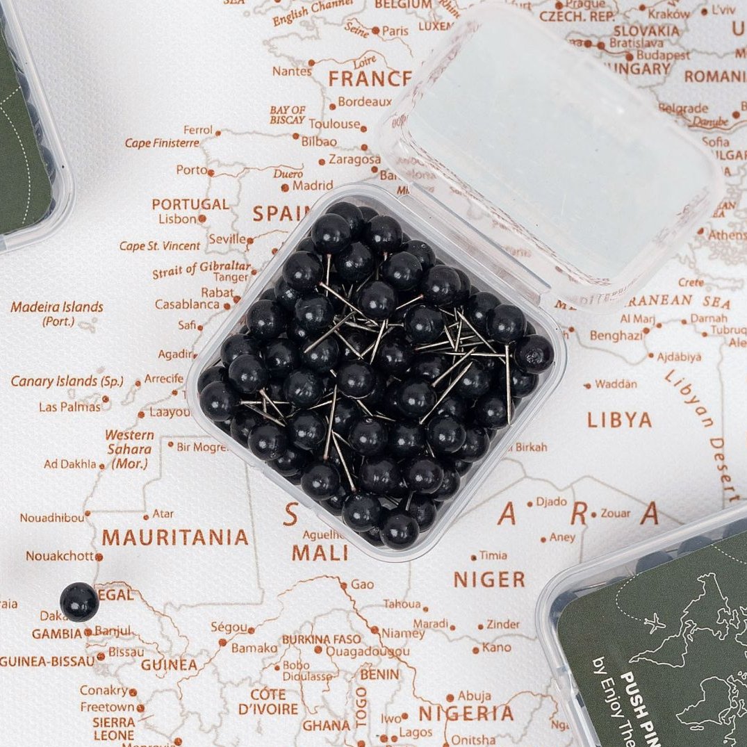 Bold black push pins used to highlight locations on a light-colored travel map