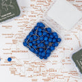 Close up of blue canvas push pins placed on a wooden wall map