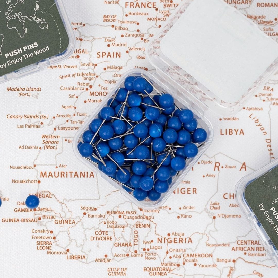 Close up of blue canvas push pins placed on a wooden wall map