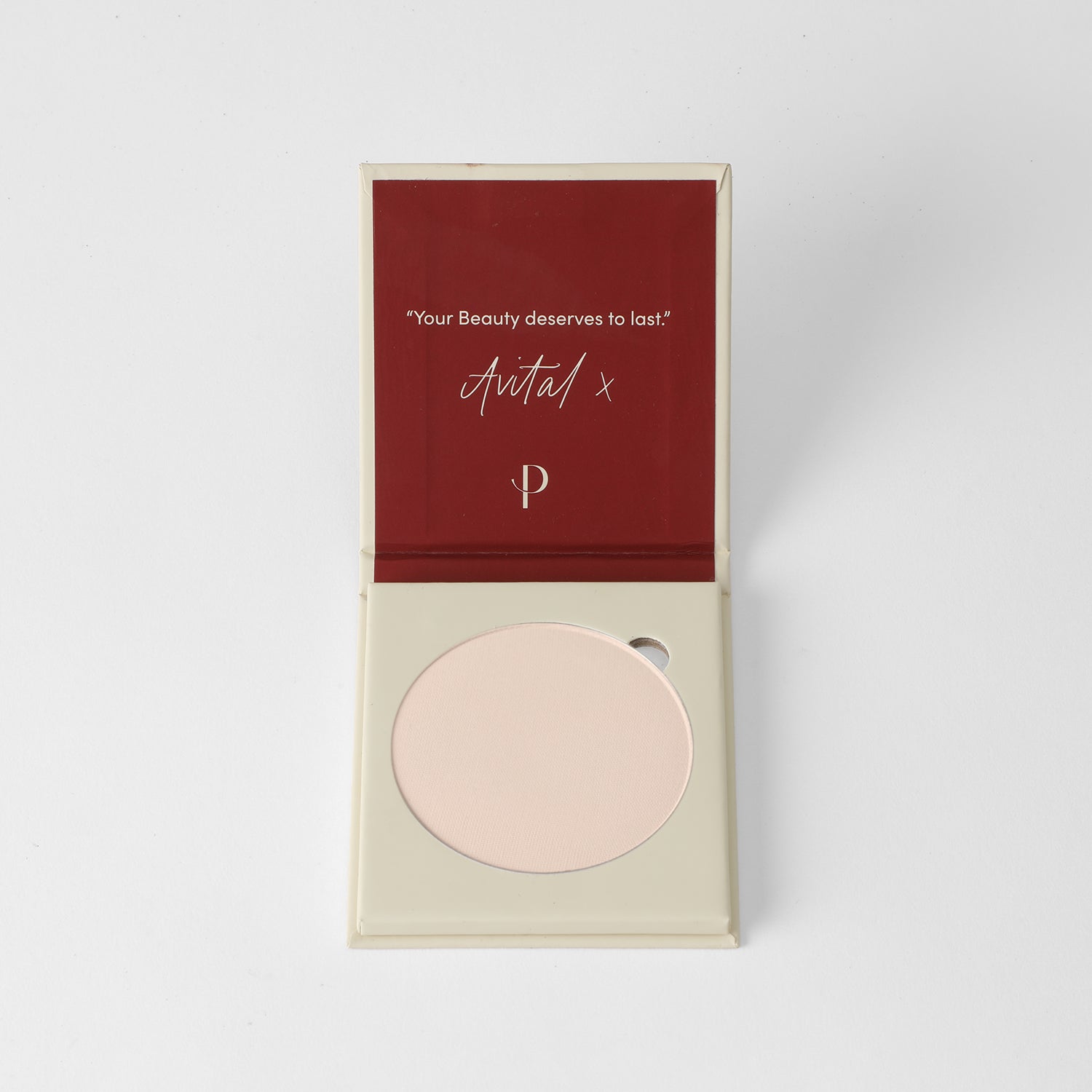 Pressed face powder in a minimalist compact, available in beige, tan, and brown.