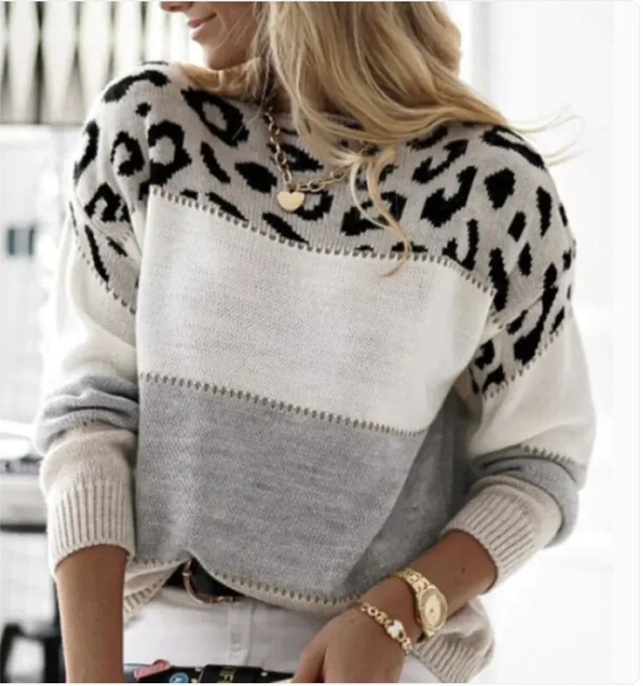 A woman wearing a cozy leopard print and color-blocked knit pullover sweater with a loose fit.