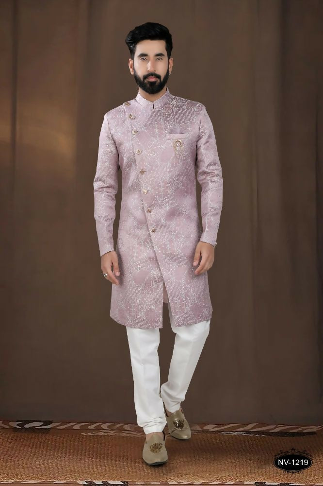 A toddler wearing a pink woven jacquard kurta with white pyjamas for a festive occasion