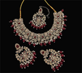 A luxurious Joban Fashion maroon stone work necklace set including earrings and tikka on a display background