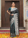 A beautiful teal silk saree with matching blouse piece, showcasing a smooth, elegant drape.