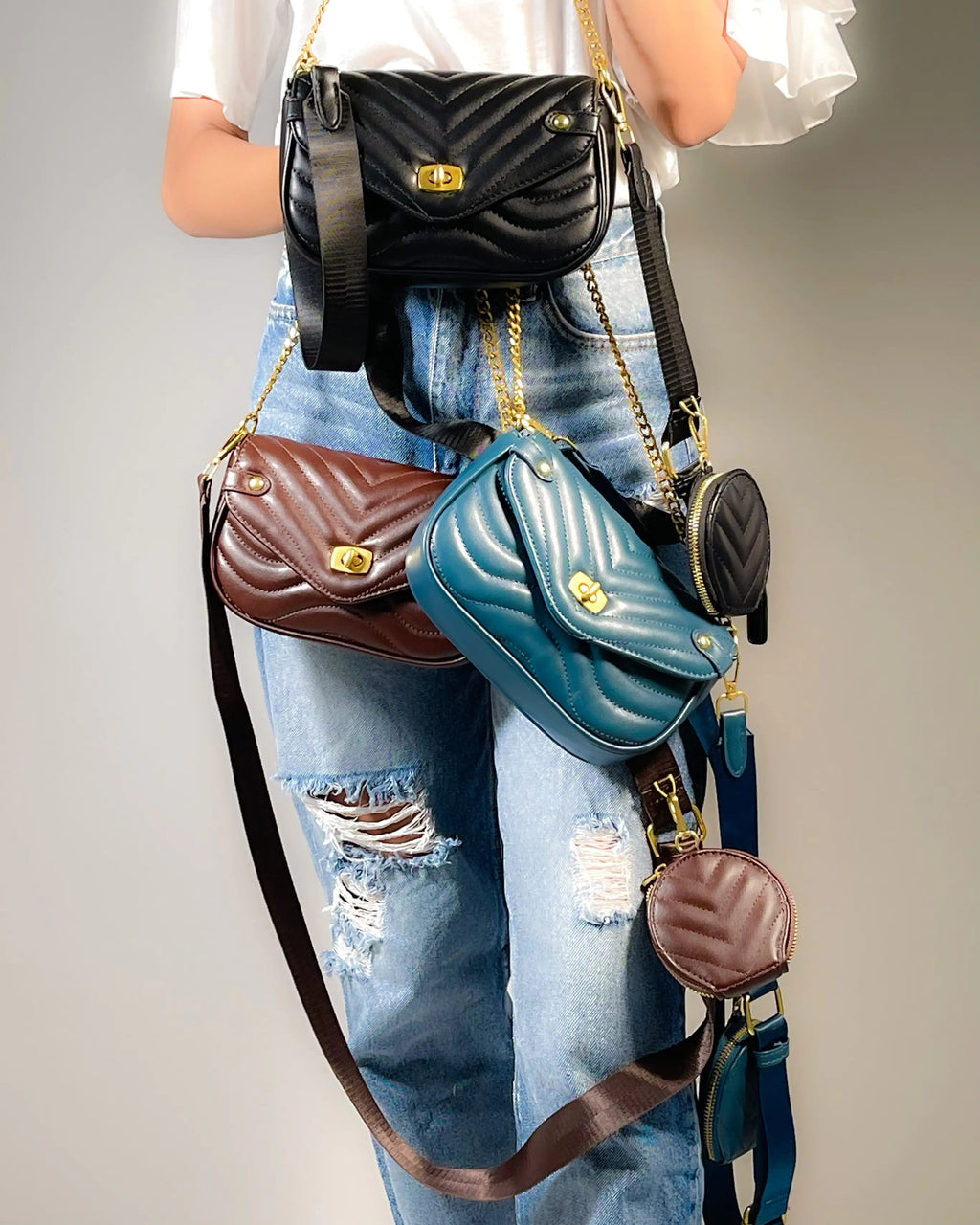 Person wearing multiple handbags on a plain background