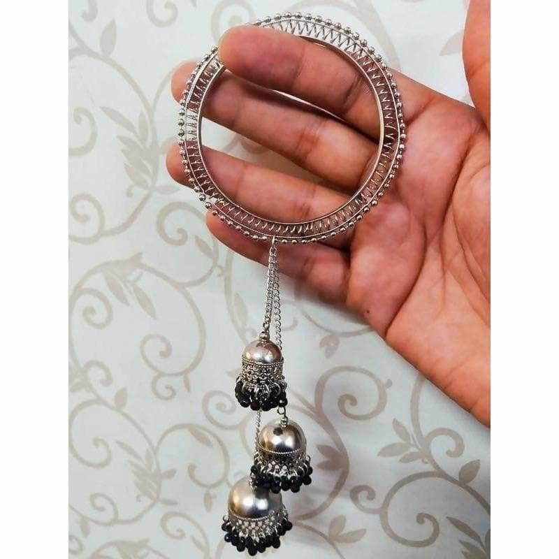 Wide silver bangle with black pearl details and three-step jhumka hanging charms