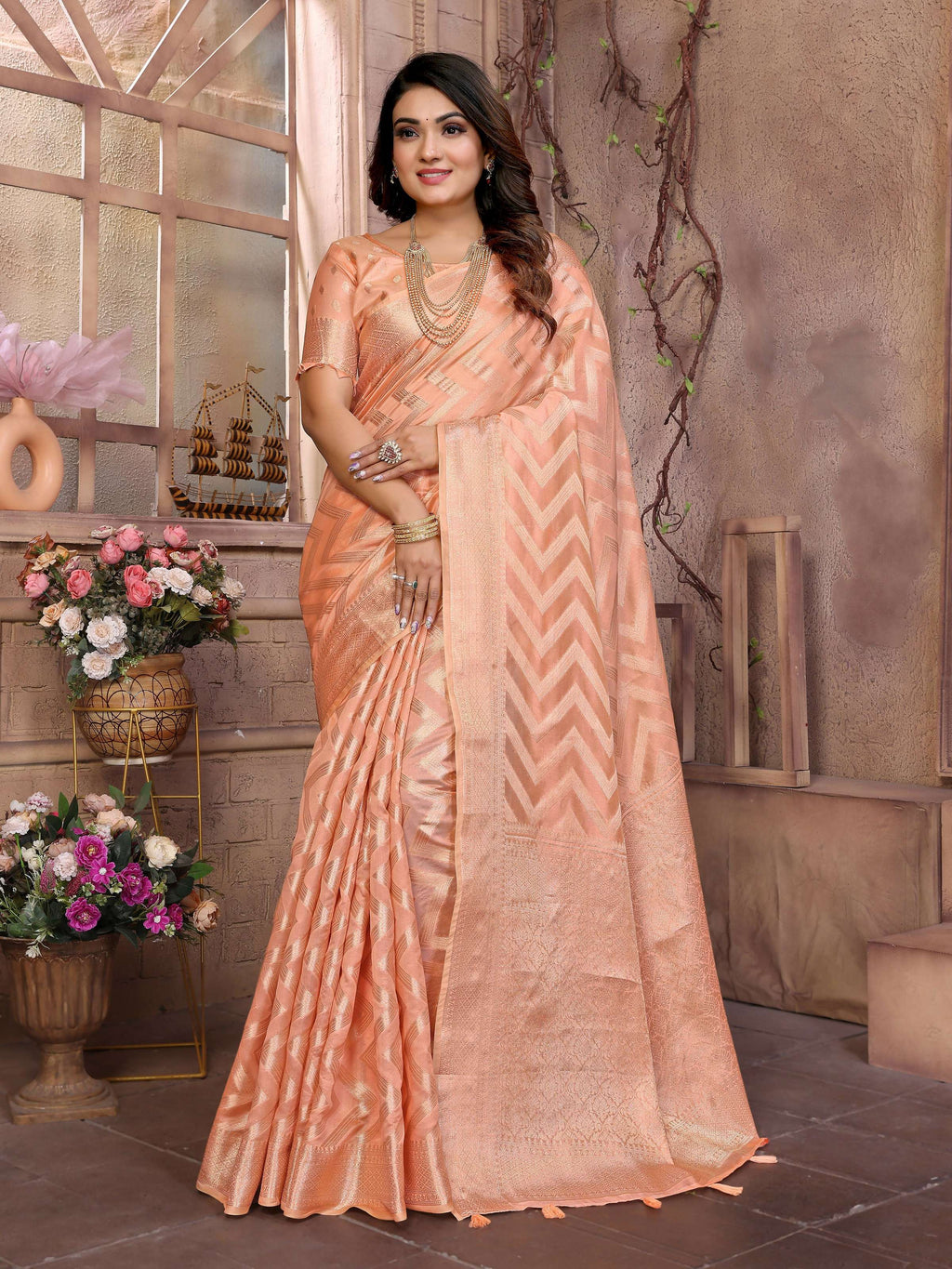 Delicate peach soft organza silk saree with elegant woven patterns.