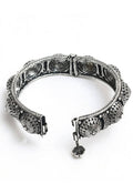 Close-up of a handcrafted oxidised silver-plated bracelet with intricate design patterns