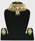 A luxurious green Kundan stone studded jewellery set with gold-plated alloy finish on a neutral background.