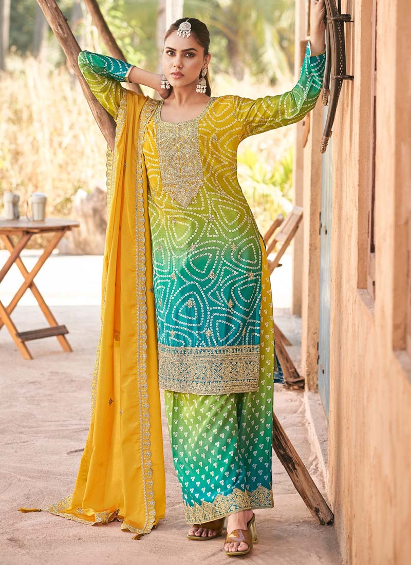 Woman wearing a yellow premium Chinon palazzo suit with heavy embroidery and hand-work detail.
