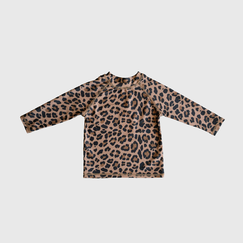 Child wearing a long-sleeve leopard print rash guard with a crew neckline at the beach