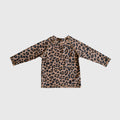 Child wearing a long-sleeve leopard print rash guard with a crew neckline at the beach