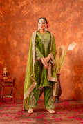Woman wearing an olive green velvet kurta set with intricate embroidery