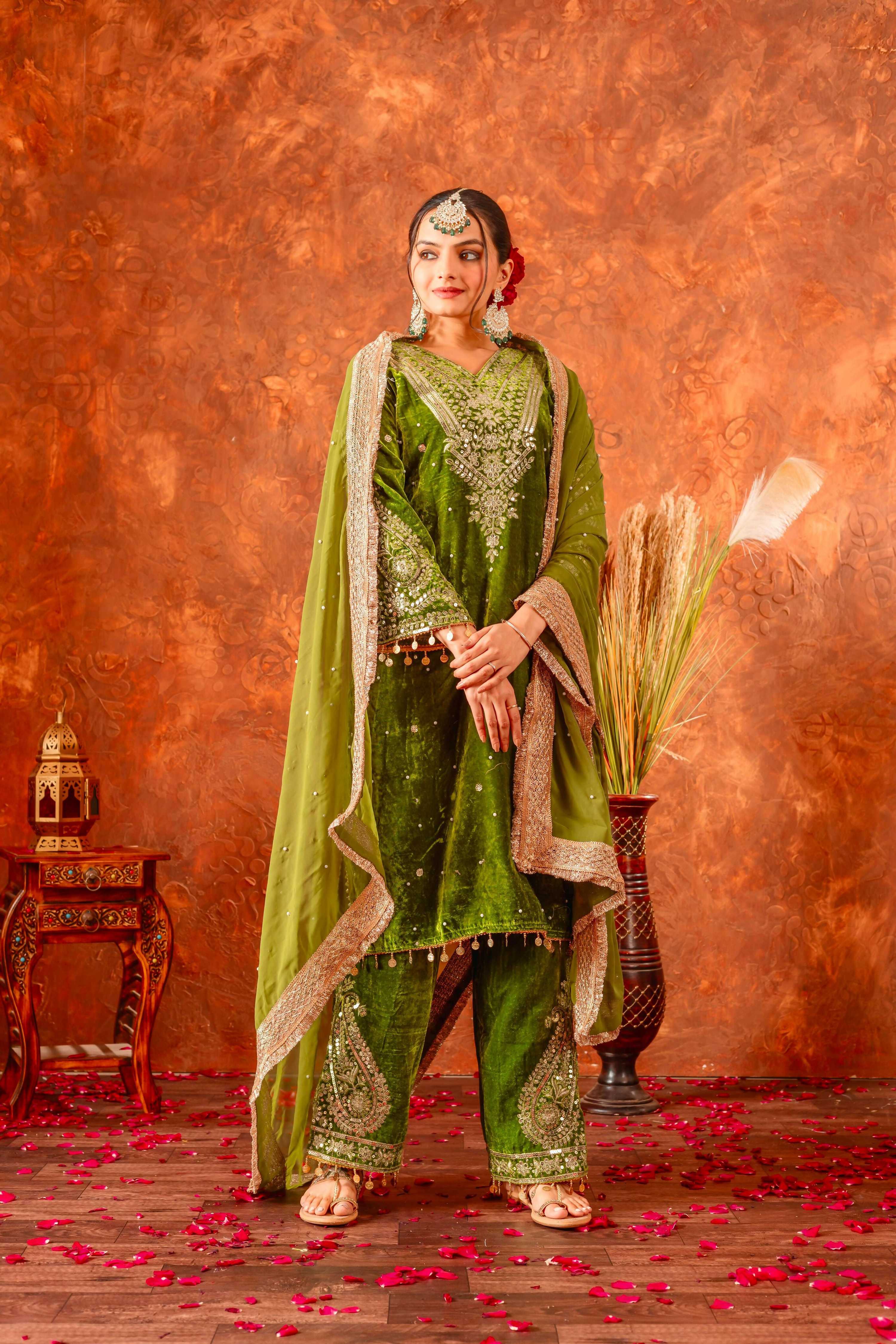 Woman wearing an olive green velvet kurta set with intricate embroidery