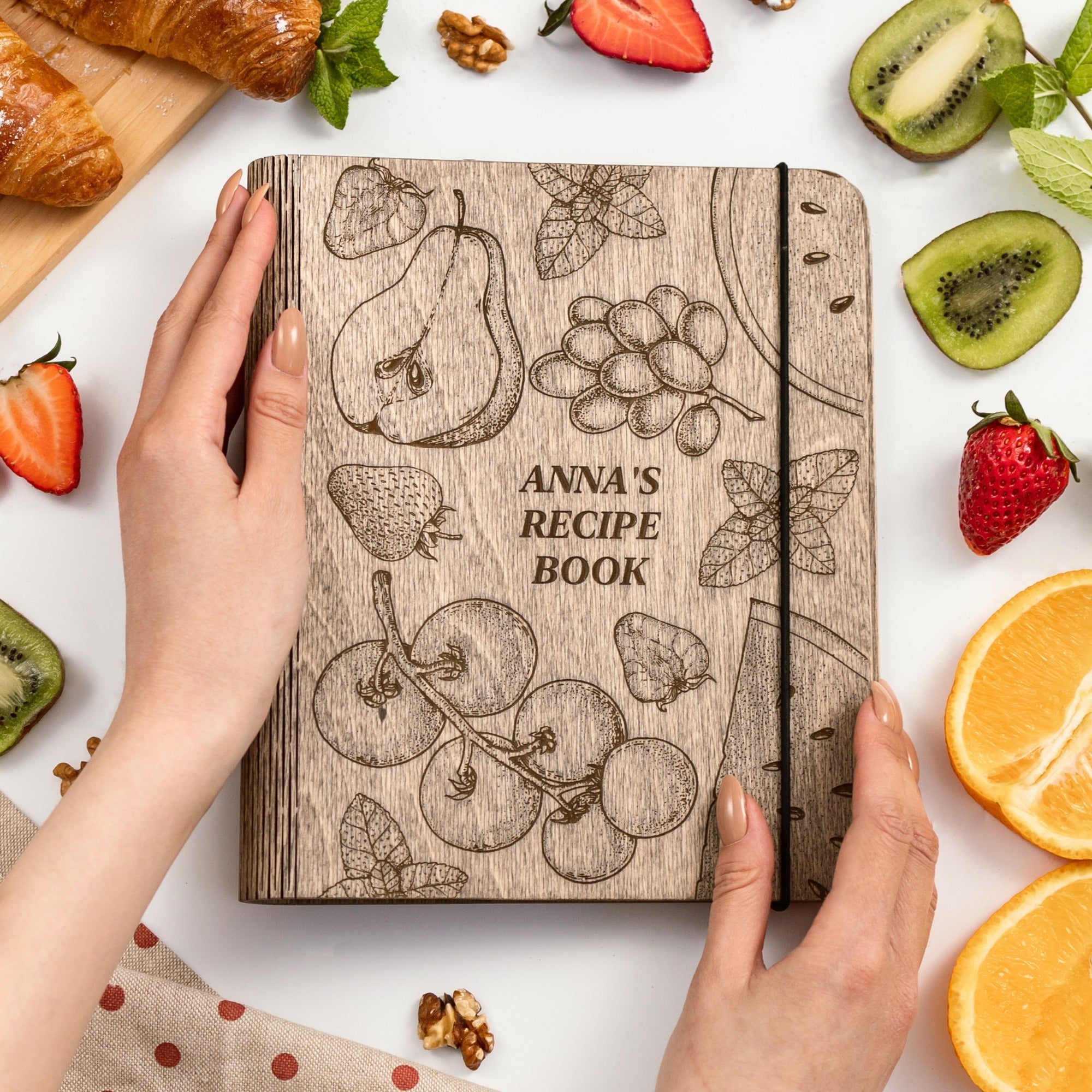Wooden-covered recipe journal with fruit-themed design.