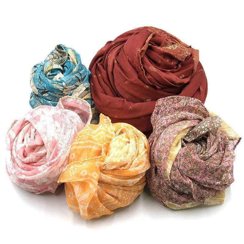 A colorful, vibrant pile of assorted upcycled sari fabric scraps for DIY baby and nursery crafts.
