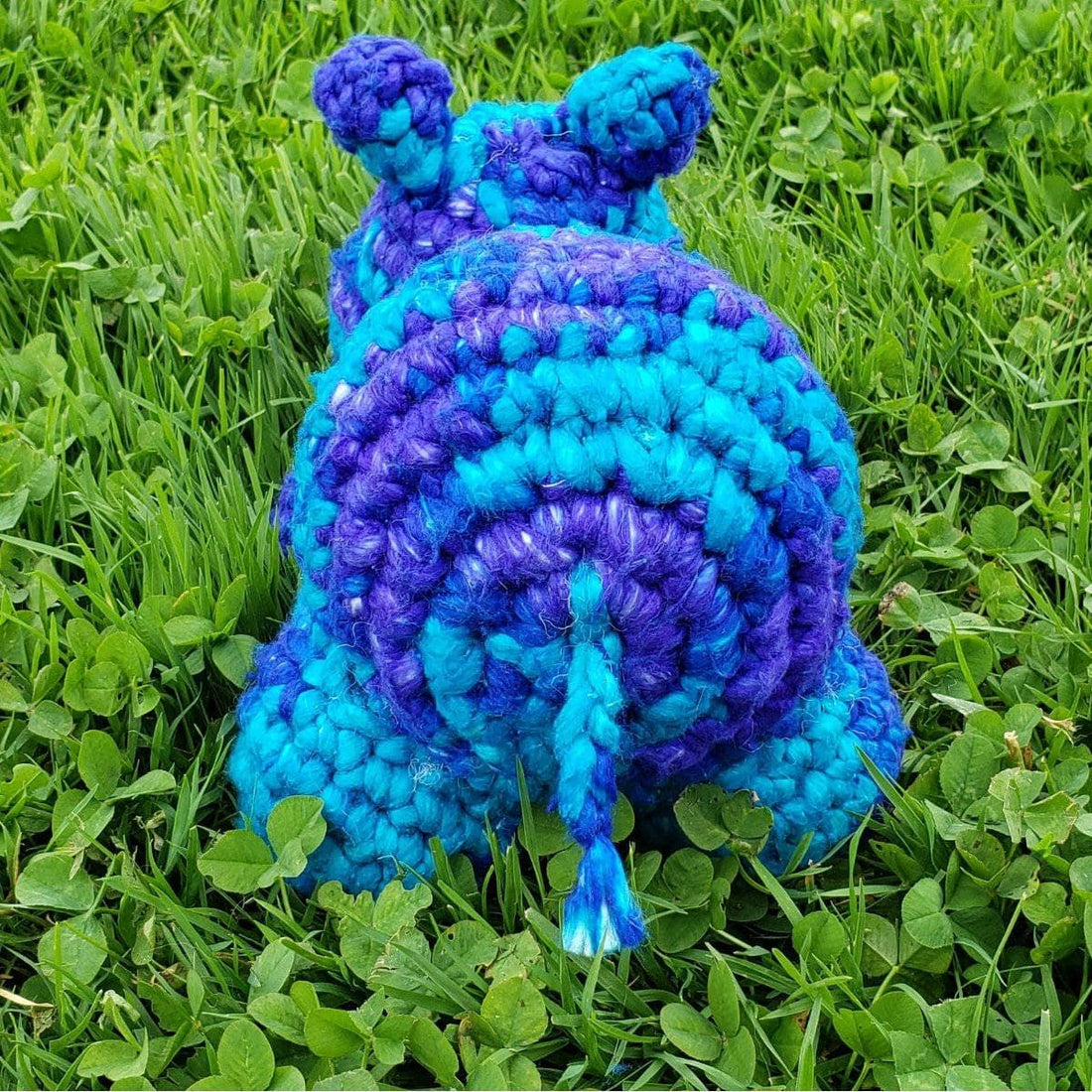 A handmade crochet baby hippo toy made from soft, bulky recycled silk yarn