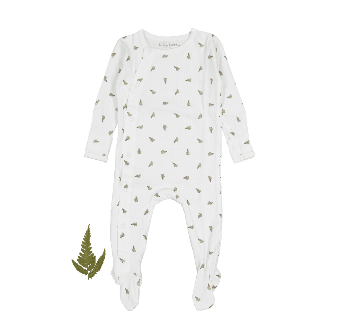 A baby's ribbed white romper with a small green leaf print, displayed flat with a single fern leaf beside it.