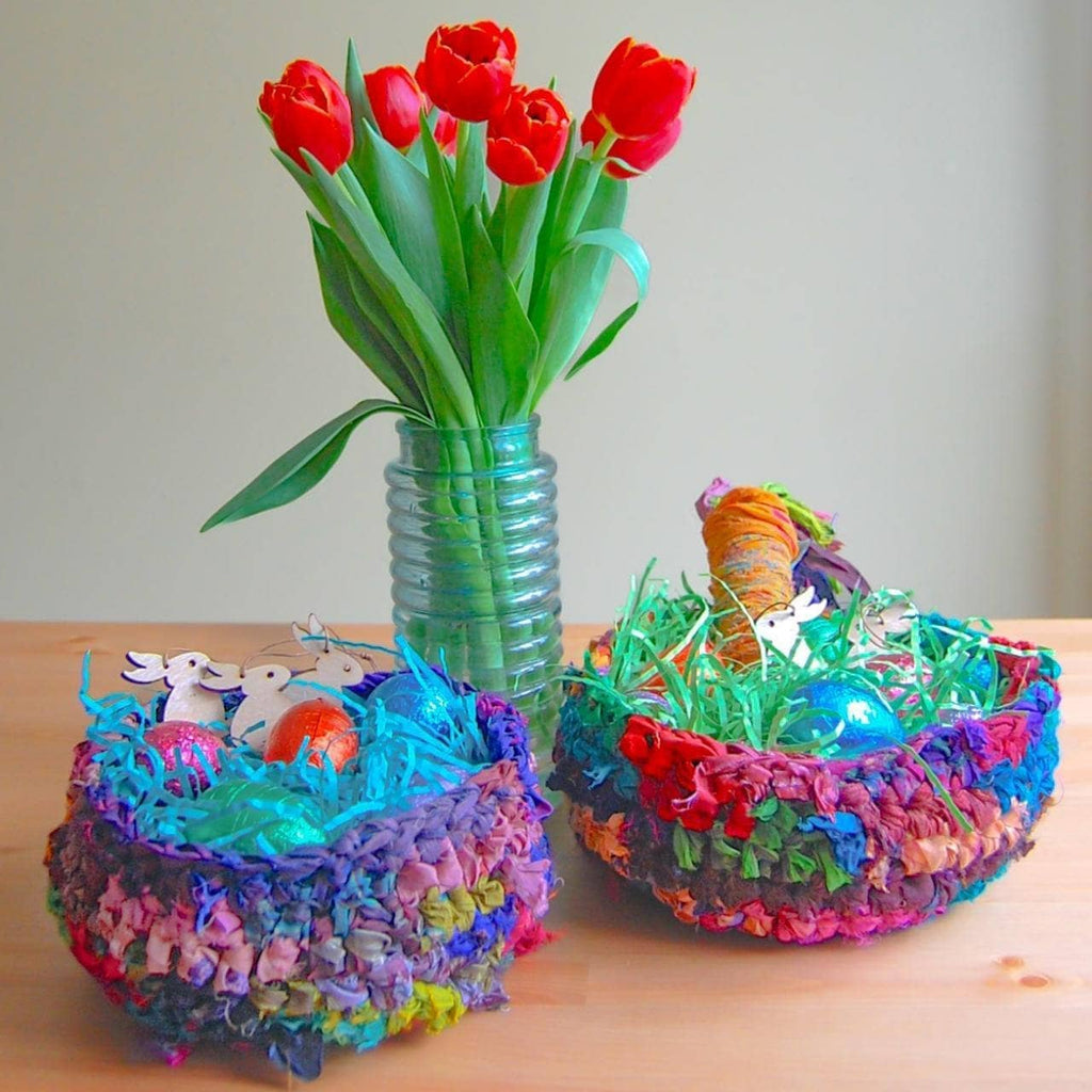 Vibrant, multicolor handmade bohemian nesting baskets sitting on a wooden surface.