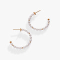Gold hoop earrings decorated with white rice pearls, featuring a romantic minimalist aesthetic.