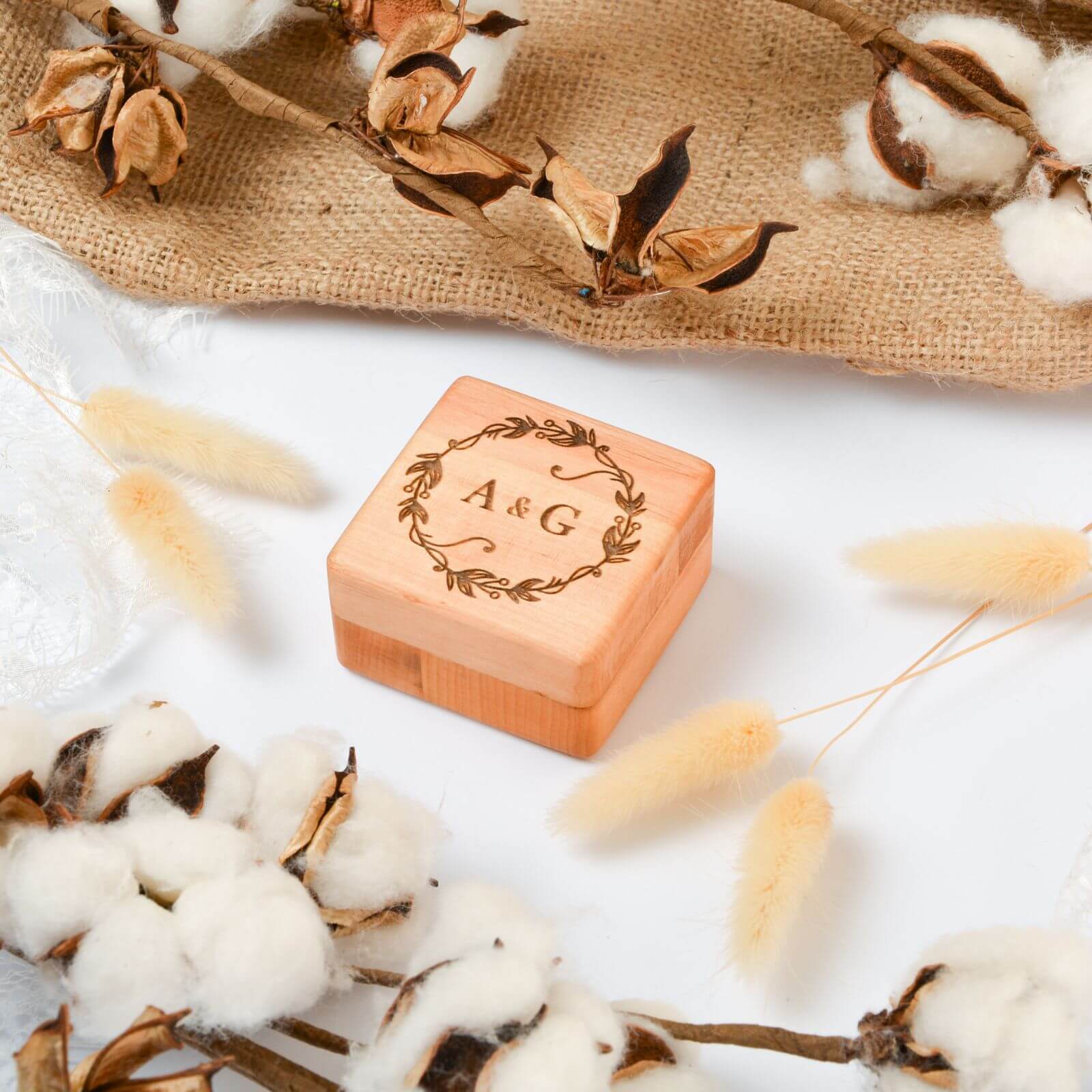 A light-brown minimalist wooden ring box for a rustic wedding ceremony