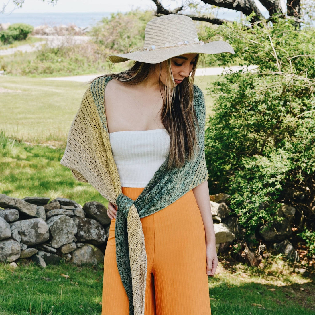 Finished Ripple in the Sand Shawl knit with ombre yarn draped over a shoulder