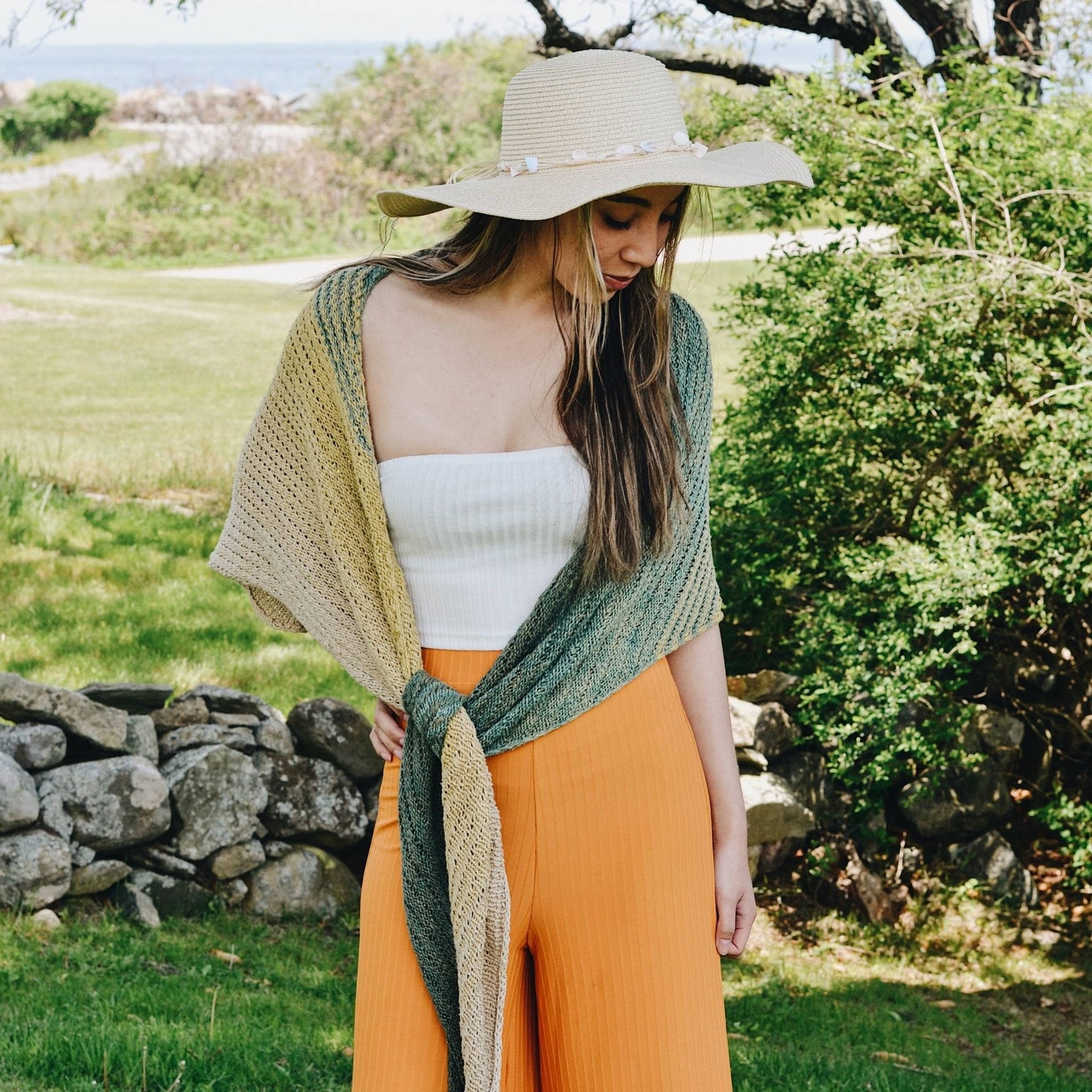 Finished Ripple in the Sand Shawl knit with ombre yarn draped over a shoulder