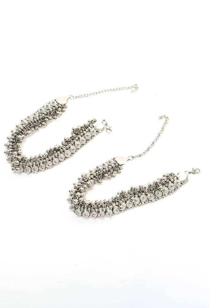 Close up of heavy oxidised silver traditional anklets featuring intricate ethnic patterns