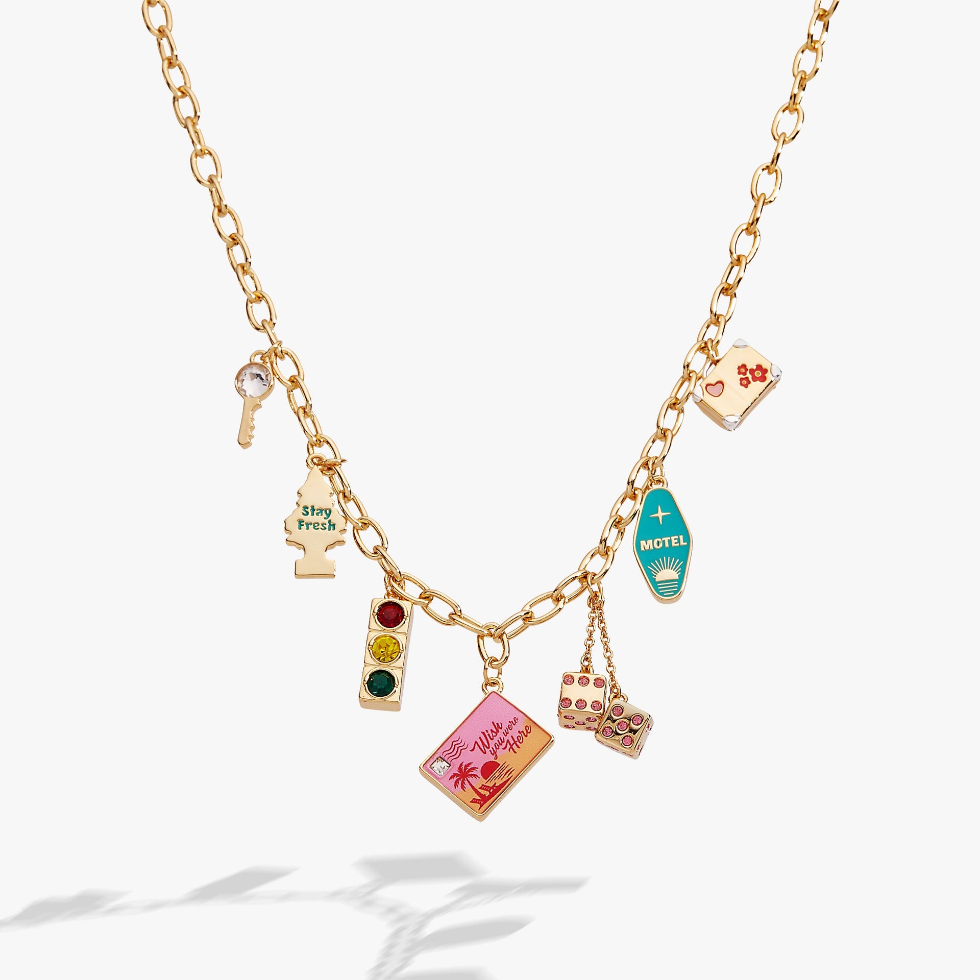 Road Trip multi-charm necklace featuring enamel charms of a car key, traffic light, and suitcase on a gold chain.