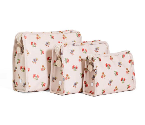 Set of three floral-patterned toiletry bags on a white background
