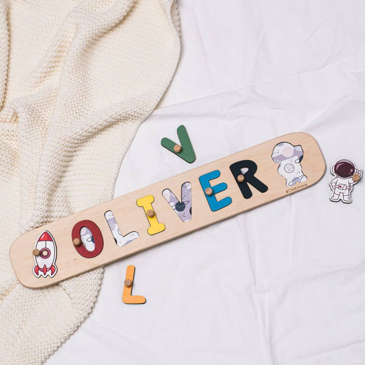 Colorful wooden rocket-themed name puzzle on a white background
