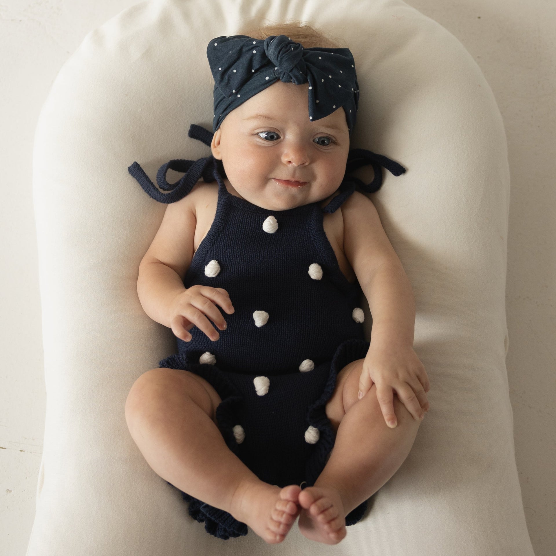 Emery Knit Ruffle Romper in Navy Blue with Cream Pom Poms