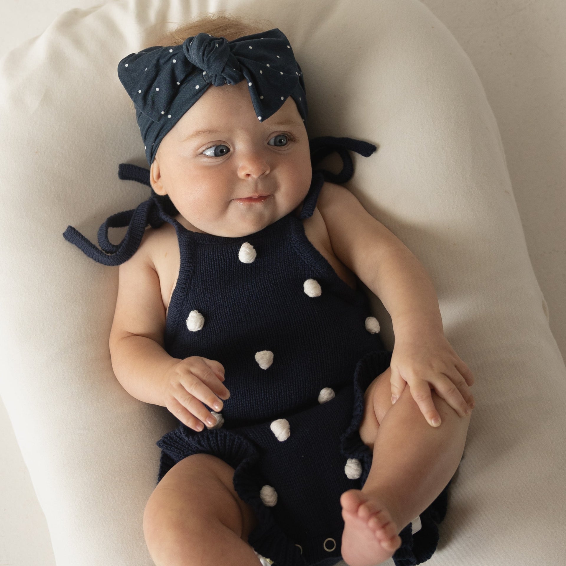 Emery Knit Ruffle Romper in Navy Blue with Cream Pom Poms