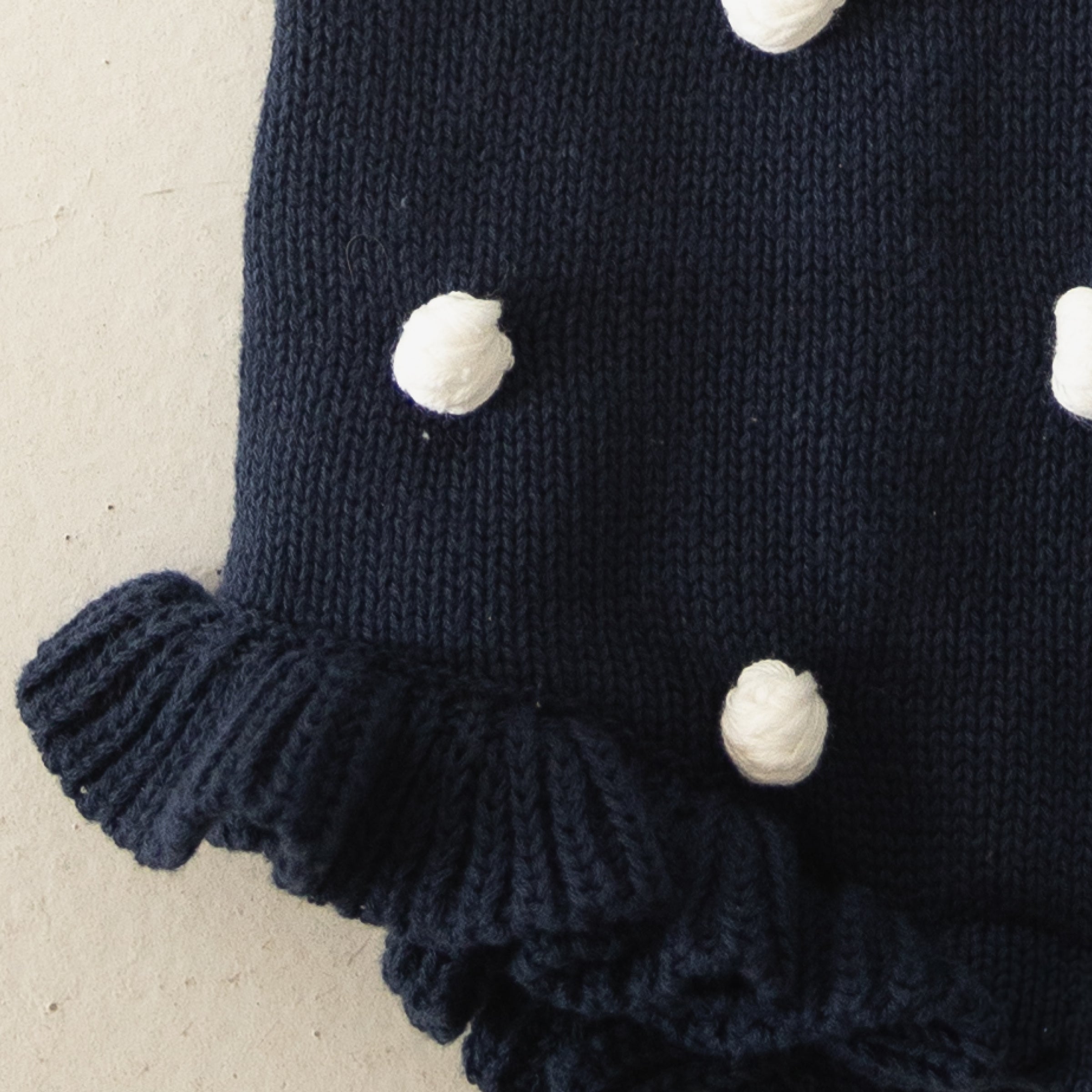 Emery Knit Ruffle Romper in Navy Blue with Cream Pom Poms