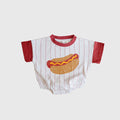Baby wearing a short sleeve romper with a whimsical hot dog print and red pinstripes against an off-white background.