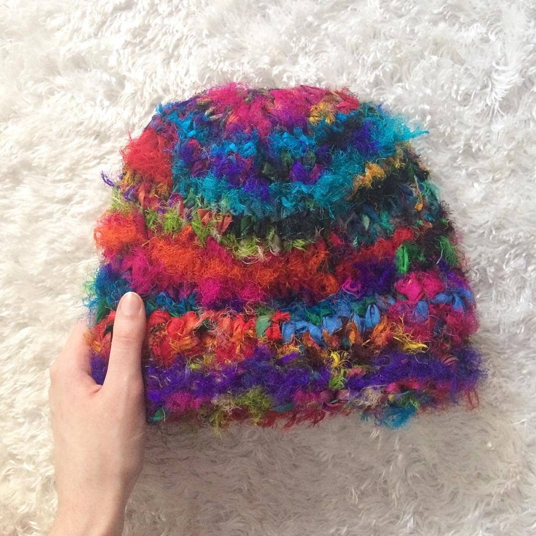 Romy Beanie Knitting Kit with colorful skeins of yarn in magenta, purple, teal, orange, yellow, and nude.