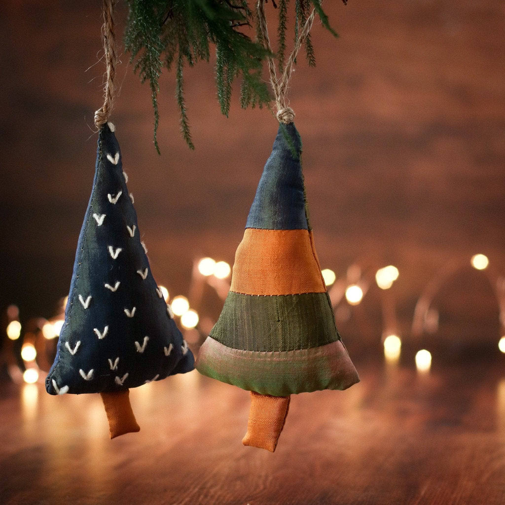 Rustic Christmas tree ornaments made from navy, red, green, and mustard cotton fabric on a wooden table.