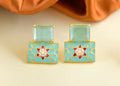 Close up of elegant mint green onyx earrings with brass settings.