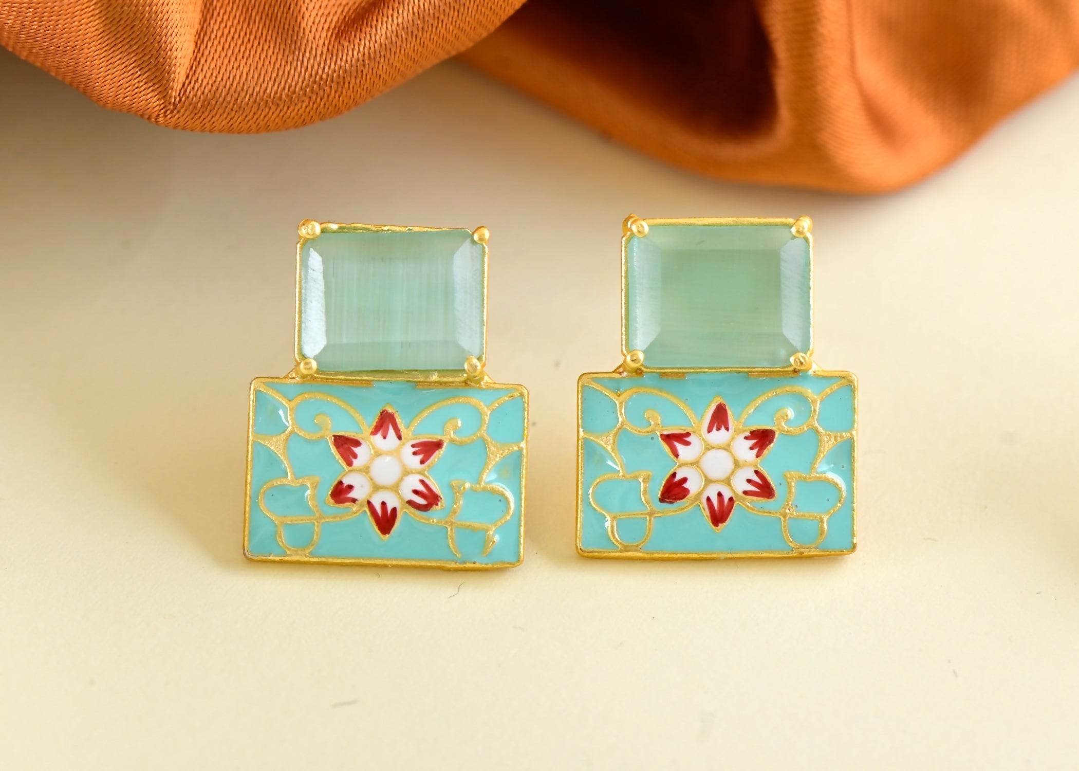 Close up of elegant mint green onyx earrings with brass settings.