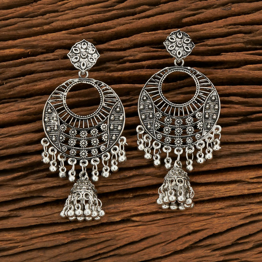 A pair of silver black oxidised metal earrings for women, featuring intricate traditional patterns.