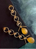 Close up of gold plated zigzag earrings with Monalisa stone detailing