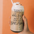 A 20oz clear glass tumbler featuring the text 'Today's Mood: Witchy With a Side of Sarcasm' held in a hand.
