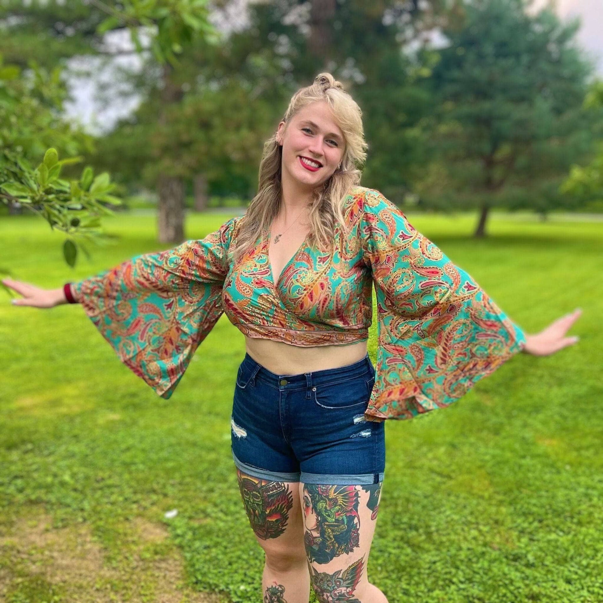 Model wearing a unique, vibrant recycled sari wrap top with dramatic bell sleeves.