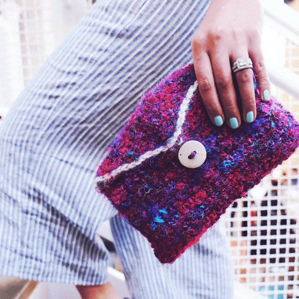 Handmade artisan crochet clutch in magenta, blue, and white silk yarn