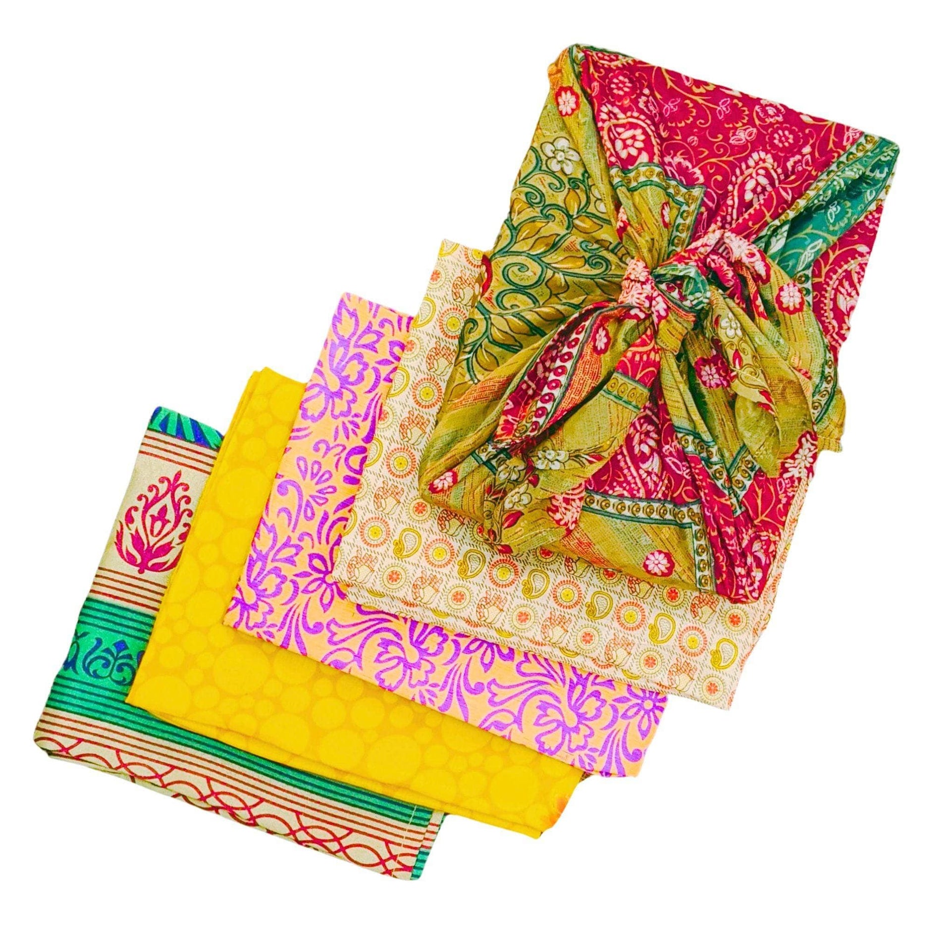 Vibrant sari silk Furoshiki wrap in pink, yellow, green, and orange used as gift wrapping and a head scarf.