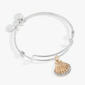 Two-tone textured wire bangle featuring a crystal-encrusted scallop seashell charm.
