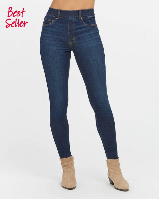 Woman wearing slim-fit high-rise ankle skinny jeans in a dark midnight shade with a flat pull-on front.